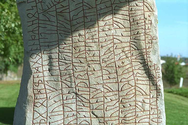 Detaljbild av baksidan av Rökstenen med runorna i långa vertikala rader.