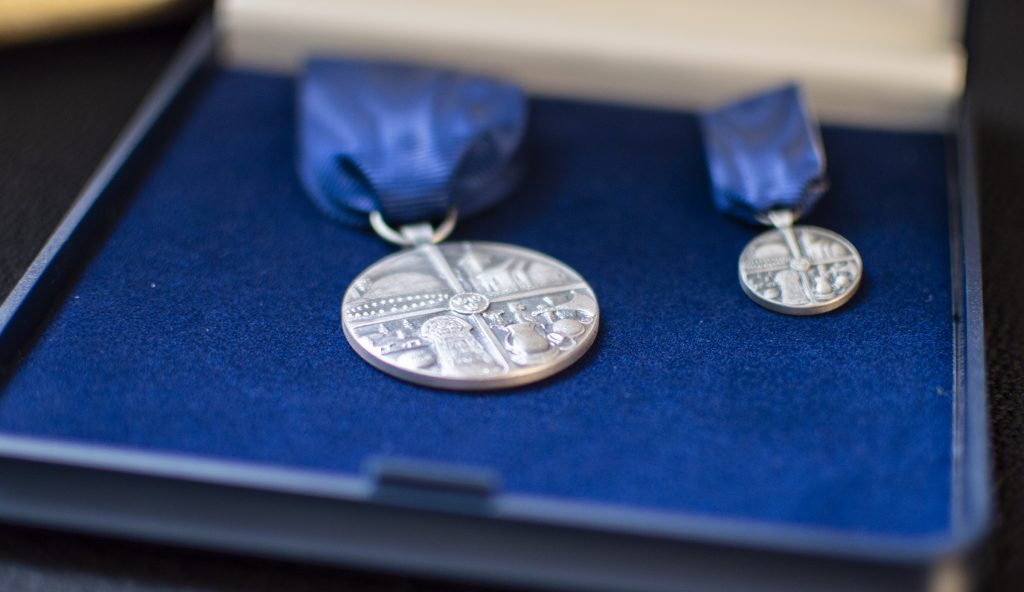 Närbild på självamedaljen och en liten miniatyrmedalja, i ask med blå sammet