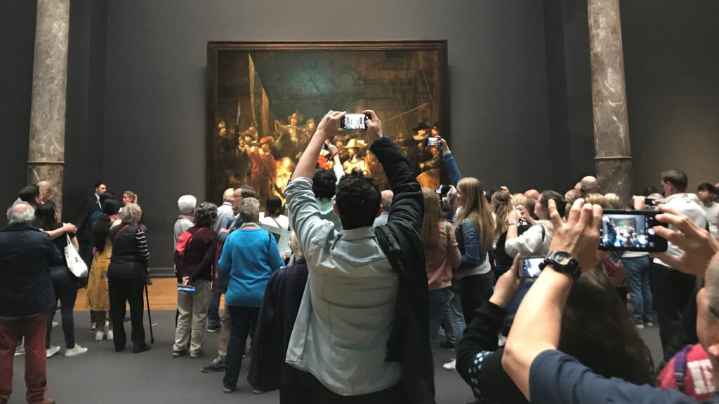 Besökare på Rijksmuseum håller upp mobilkameror framför Rembrandts målning Nattvakten.