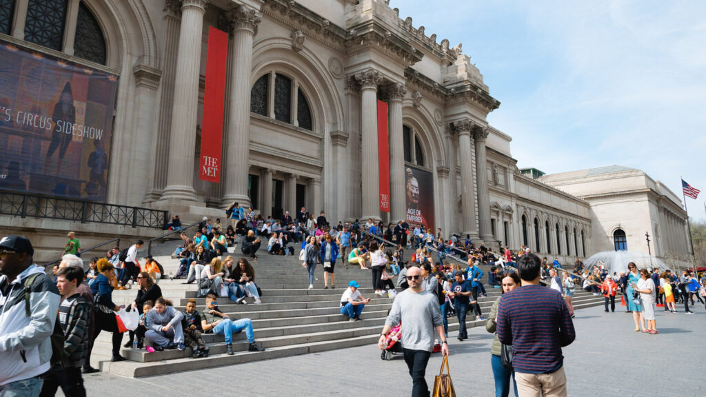 Människor vid entrén till Metropolitan Museum of Art en solig dag.