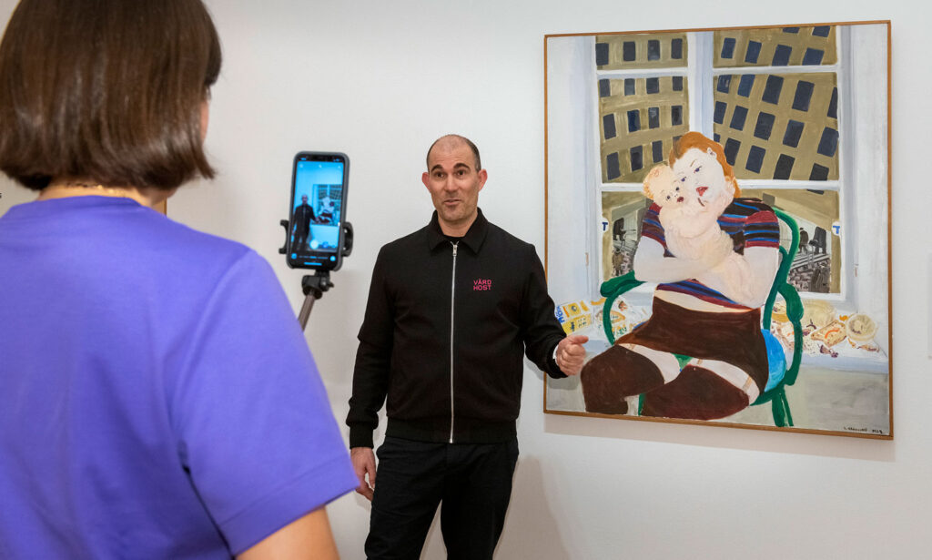 Museimedarbetare på Moderna Museet visar konst medan en kollega filmar honom med en mobiltelefon