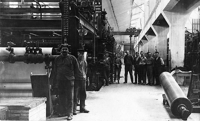 Svartvitt foto föreställande arbetare på pappersbruk, 1900-talets tidigare hälft.