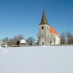 En kyrka på avstånd i ett snöigt landskap.