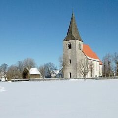 En kyrka på avstånd i ett snöigt landskap.