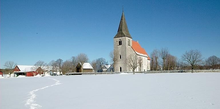 En kyrka på avstånd i ett snöigt landskap.