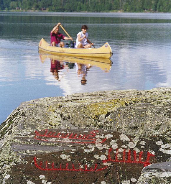 Kanotister i sjön Råvarpen, Dalsland. I förgrunden ses Högsbyns hällristningar.