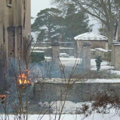 Stenhus med trädgård som har skadats av brand.