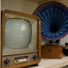 En gammal tv-apparat och gramofonspelare på en lagerhylla.