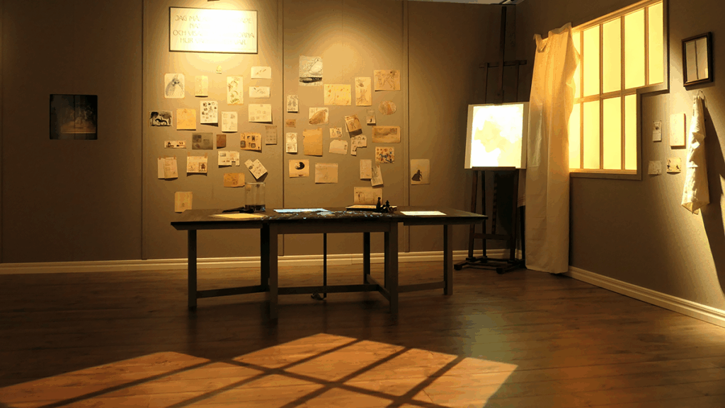 Ett rum för kreativa idéer, på väggen sitter massor av lappar framför ett stort arbetsbord.Solen lyser på golvet där fönsterutorna avspeglas.