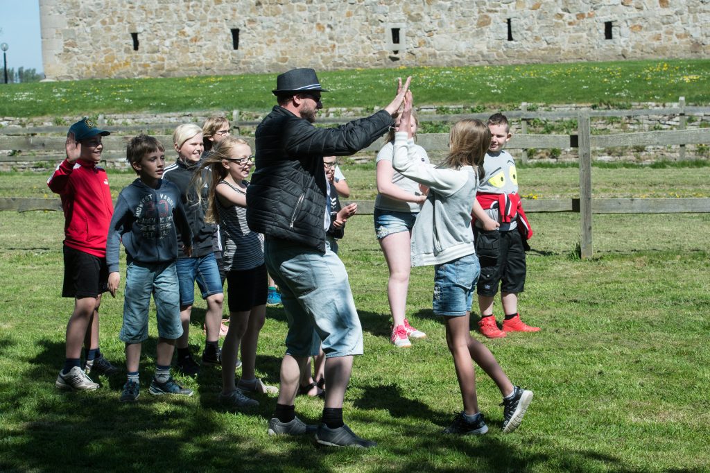 Elever gör "high five" med sin lärare.