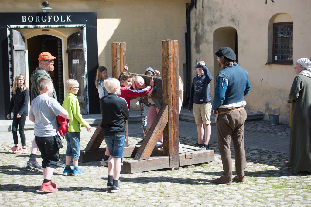 Grupp av personer står på gården vid Glimmingehus