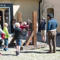 Grupp av personer står på gården vid Glimmingehus