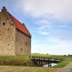 Glimmingehus sett från andra sidan vallgraven bredvid en bro.