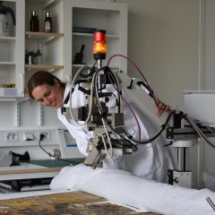 Marei Hacke på Kulturarvslaboratoriet undersöker en av fanorna med hjälp av XRF (röntgenfluorescensteknik).