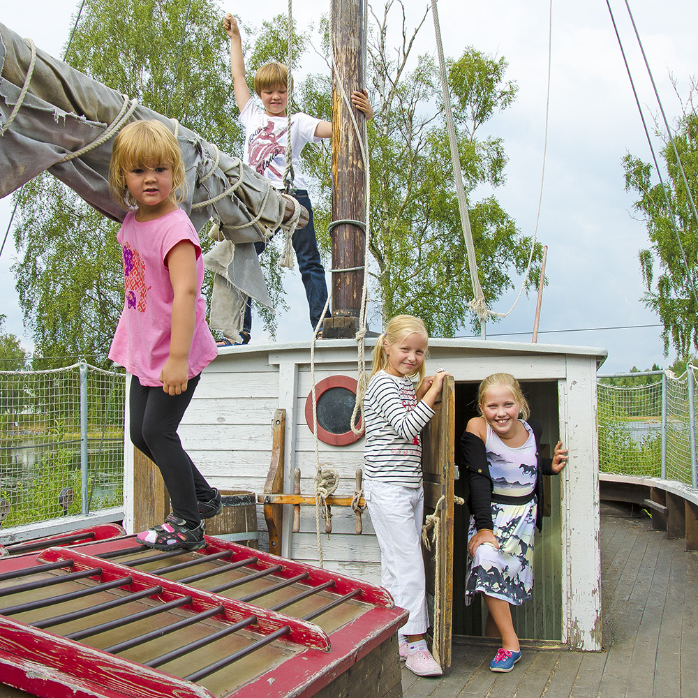 Fyra barn som leker på en lekplats utformad som en båt.