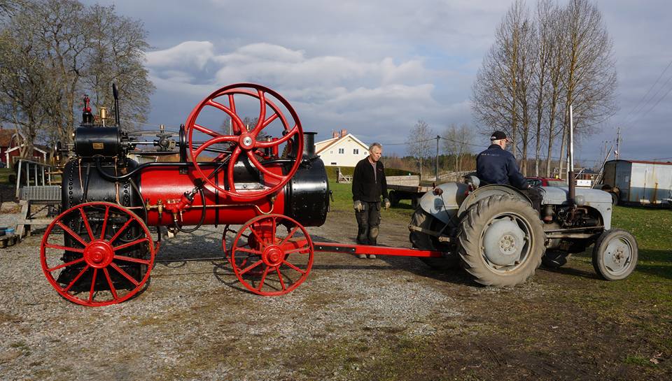 Traktor drar en ångmaskin.