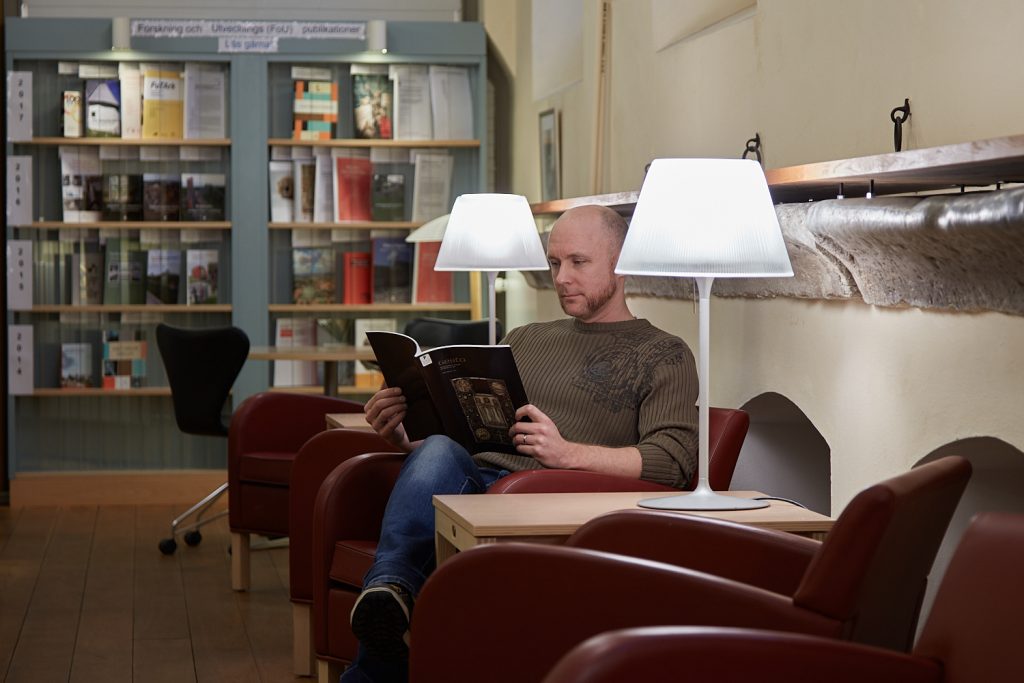 Man sitter och läser i biblioteket