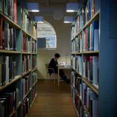 Kvinna som läser i biblioteket