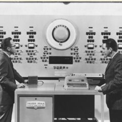 Svartvitt foto med två personer som möts i ett datorrum.