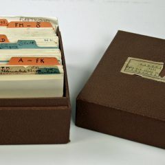 Liten brun kartotekslåda med katalogkort med texten Kartotek till Carl R. A. G:son Fleetwoods familjearkiv klistrad på locket.