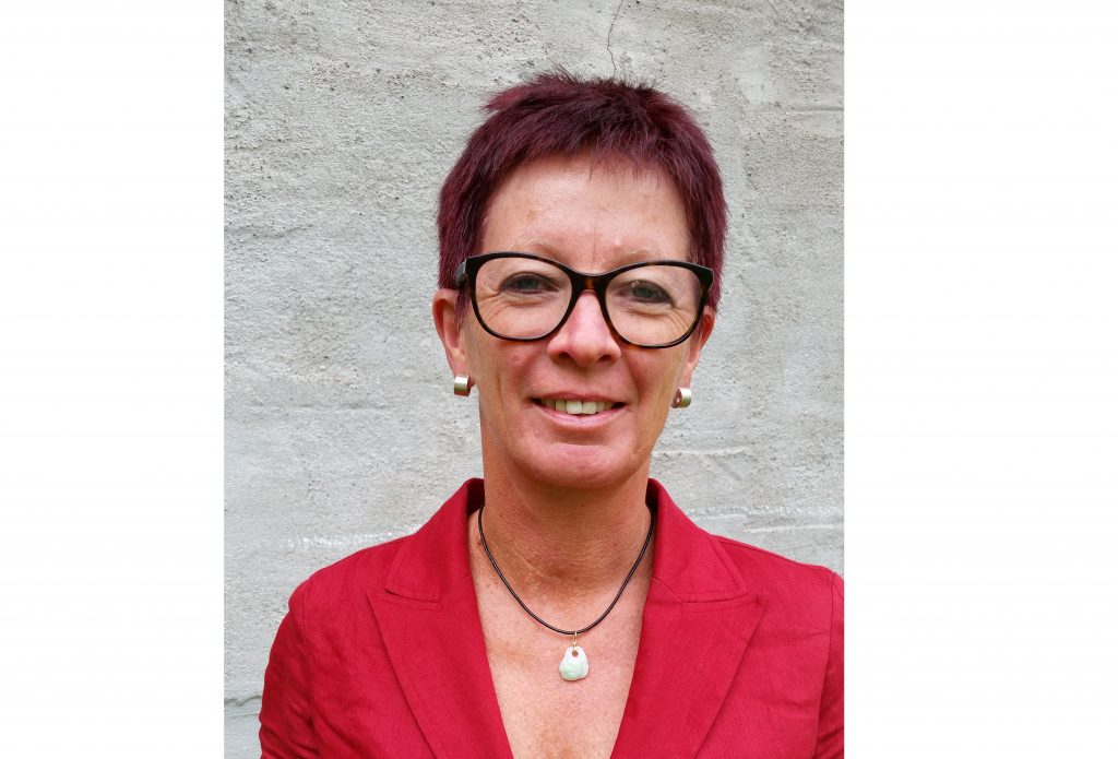 Porträtt på Liv Ramskjær, generalsekreterare för Norges museumsförbund. Hon är klädd i rött och bär glasögon med mörka bågar.