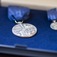 Närbild på självamedaljen och en liten miniatyrmedalja, i ask med blå sammet