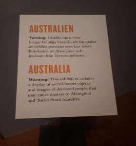 Skylt med texten Varning: Utställningen visar heliga/hemliga föremål och fotografier av avlidna personer som kan anses kränkande av Aboriginier och invånare från Torressundöarna.