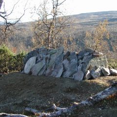 Samisk grav med staplade stenar i fjällandslkap