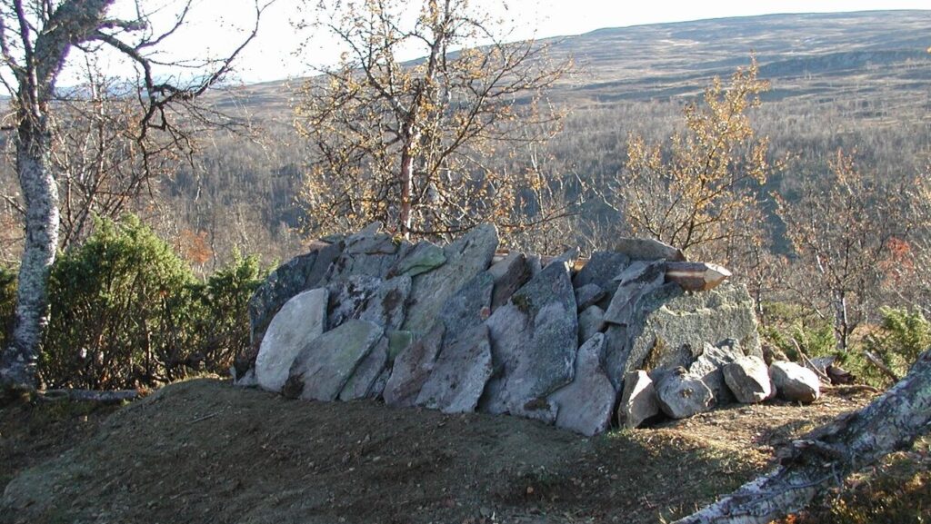 Samisk grav med staplade stenar i fjällandskap