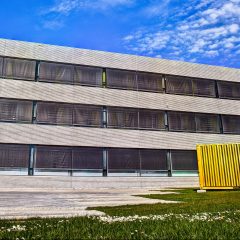 Bilden visar en fasaden vid ingången på Riksantikvarieämbets kontor i Visby. Framför står ett konstverk i regnbågens färger.