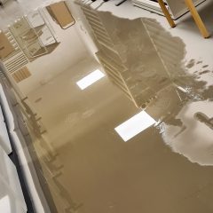 Bild på ett betonggolv som är översvämmat av vatten