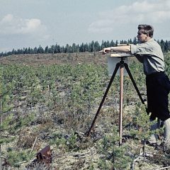 Man står i naturen med karteringsinstrument.