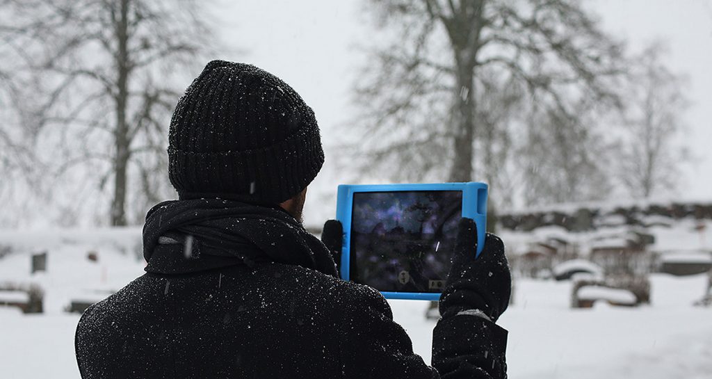 Promenerande man håller upp en iPad/skrivplatta