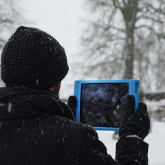 Promenerande man håller upp en iPad/skrivplatta