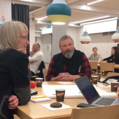 Deltagare ssitter vid olika bord och samtalar i grupper.