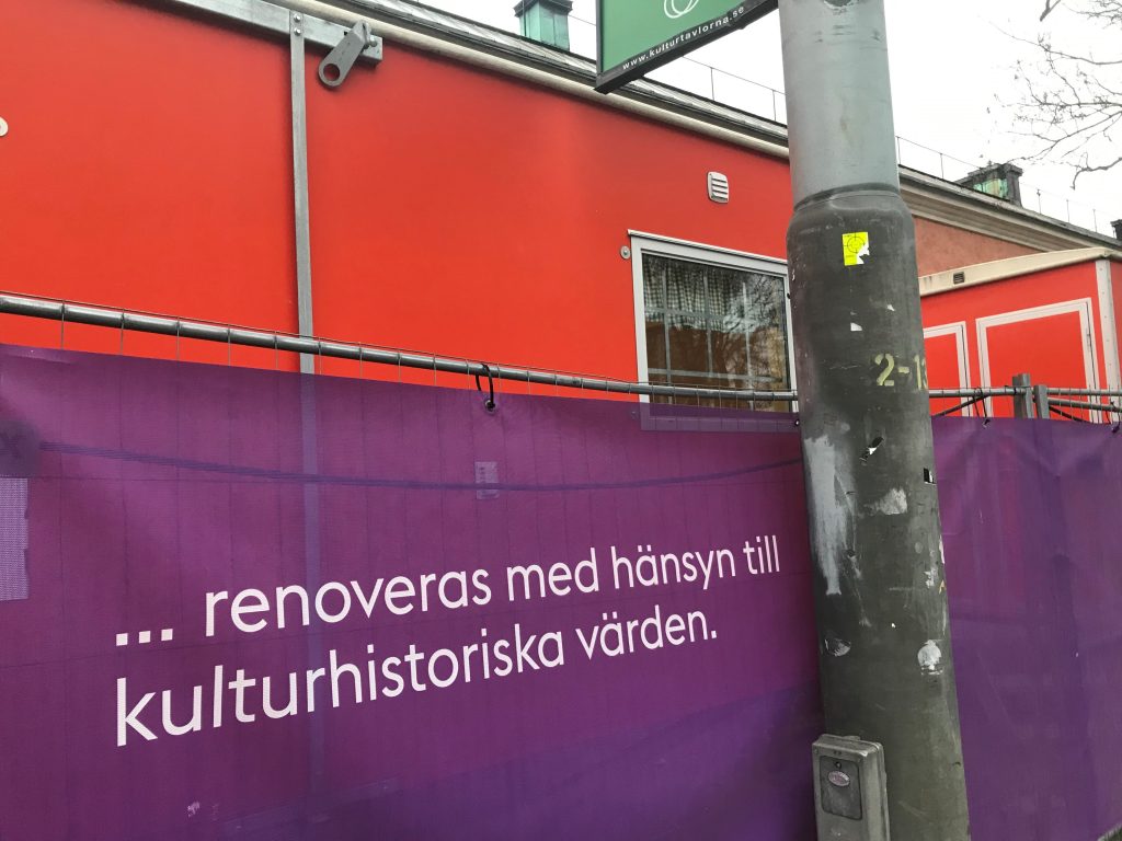 Banderoll på byggnad som informerar om att varsam renovering pågår.