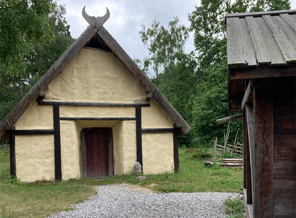 Foto på ett rekonstruerat lerklinat vikingatida hus