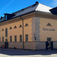 Kvinna och barn står framför entrén till byggnaden.