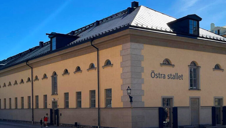 Kvinna och barn står framför entrén till byggnaden.