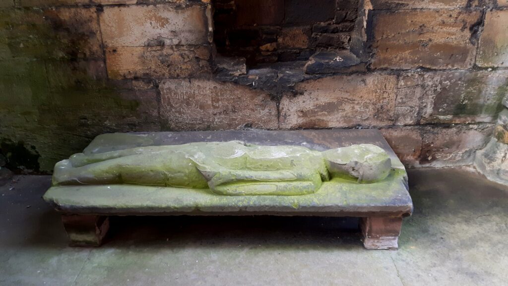 Liggande stenfigur vid Melrose Abbey, i Scotland.