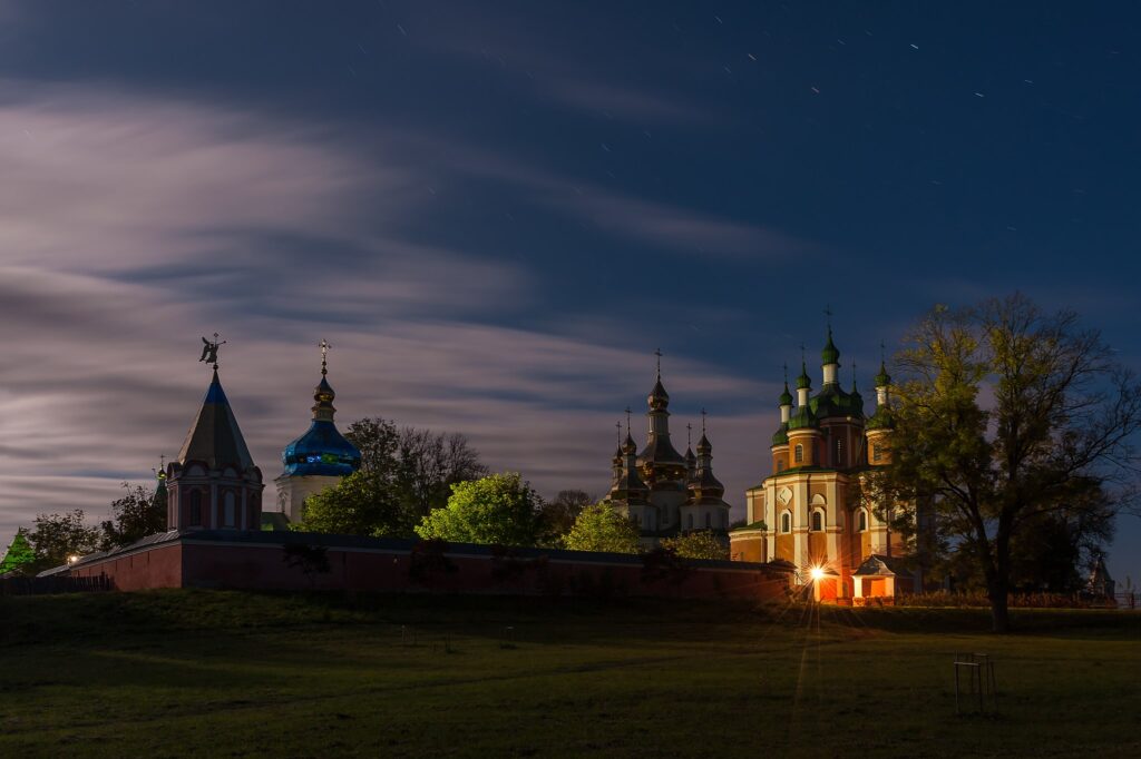 Slott i kvällsljus med upplysta lökformarde kupoler.