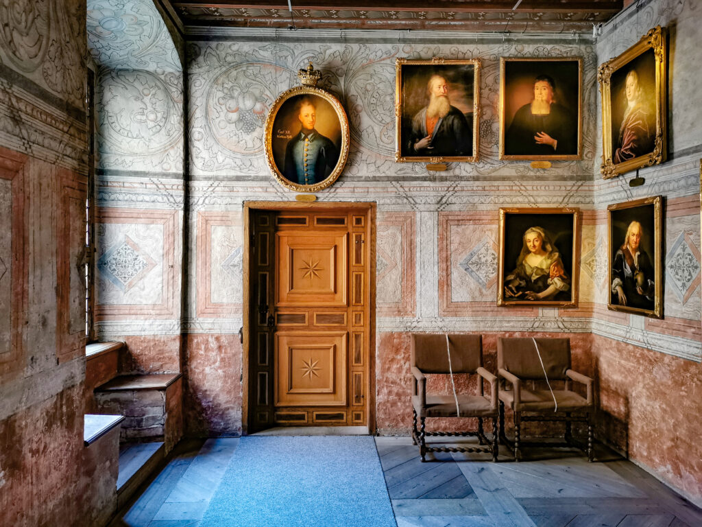 Ett ålderdomligt dom, som taget ur ett slott, med äldre porträtt på väggarna.