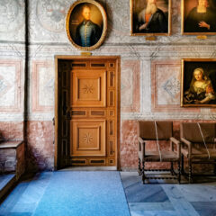 Ett ålderdomligt dom, som taget ur ett slott, med äldre porträtt på väggarna.