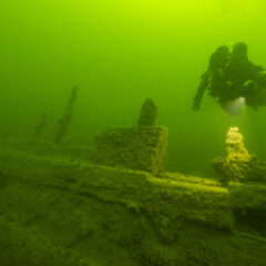 En dykare under vatten utforskar ett vrak.