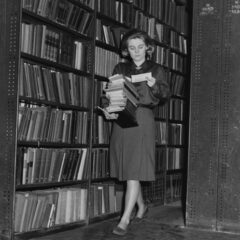 En bibliotekarie hämtar böcker i magasinen på LSE Library 1964, svartvit bild.