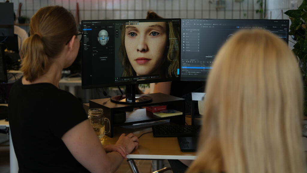 Två personer sitter vid en datorskärm där Egtvedflickans avatar tas fram.