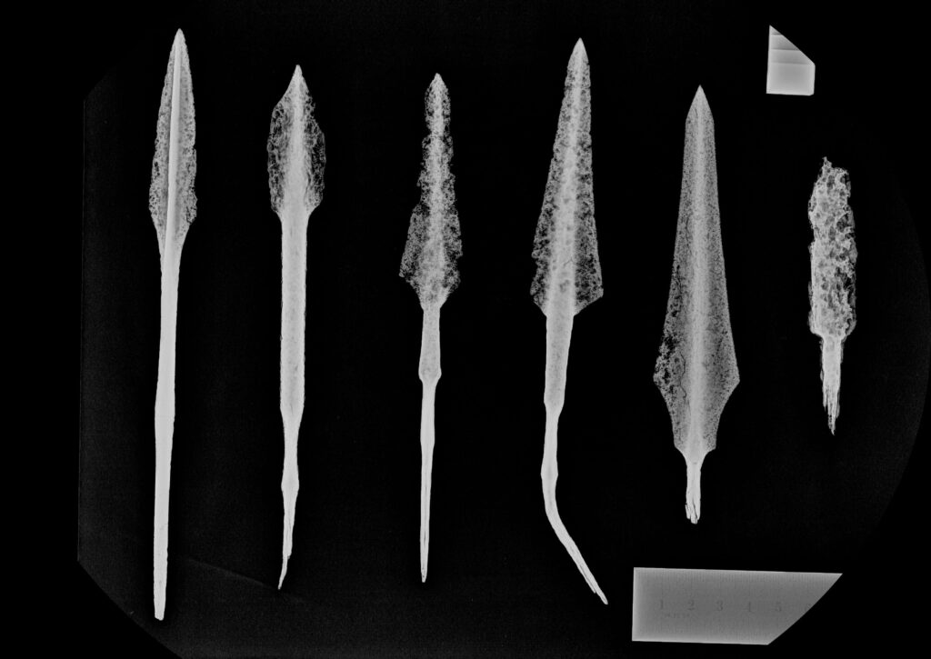 Röntgenbild av 6 olika stora pilspetsar.
