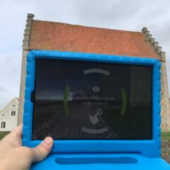 Surfplatta vars bildskärm hålles framför borgen på avstånd, så att den precis täcker byggnaden.