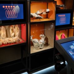 Utställning av föremål på scenkonstmuseet, i olika färgade lådor. Nedanför en digital interaktiv display.