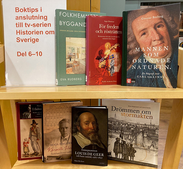Sju böcker uppställda på en bokvagn. Man kan se framsidan på alla böckerna, samt en skylt med texten "Boktips i anslutning till tv-serien Historien om Sverige. Del 6-10"
